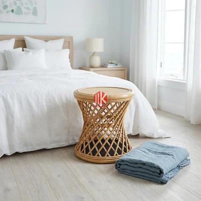 A handwoven rattan stool with a distinctive twisted base and cane top, acting as a chic accent in a minimalist boutique display.