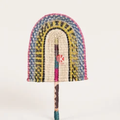 Multicolor Twill Woven Palm Leaf Hand Fan 4 A studio shot of a multicolor arched palm leaf hand fan with a brown wrapped handle against a white background.