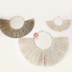 Studio shot of three fan-shaped wall hangings made of natural palm leaf strips on a pure white background.