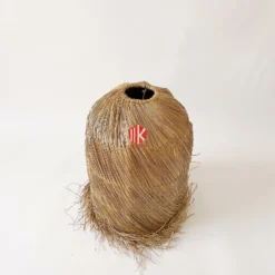 Spiral Woven Palm Leaf Lampshade with Shaggy Fringe 7 A studio shot of a tapered palm leaf lampshade showing the spiral weave pattern and shaggy fringe at the base.