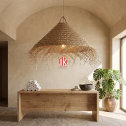 A fringed palm leaf lampshade hanging over a wooden dining table in a sunlit coastal resort.