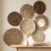 Patterned Mixed Material Round Wall Decor Set of 8 2 A set of patterned mixed material wall decor plates displayed artfully on a light-colored living room wall, creating visual interest above a console table.