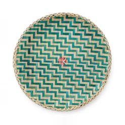 Top-down view of a round bamboo tray showing a teal and natural herringbone weave and a braided rim on a pure white background.