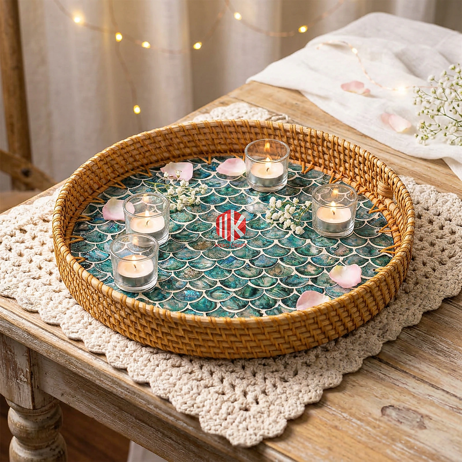 Rattan and Mother of Pearl Round Serving Tray 3 A round mixed material serving tray with a mother of pearl base sits on a rustic wooden table, holding small glass votives and scattered rose petals for an elegant event.