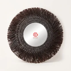 A studio shot of a round wall mirror with a wide, shaggy dark brown seagrass border on a white background.